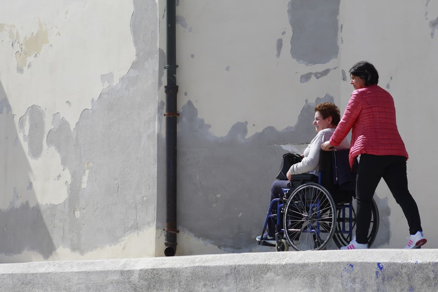 Woman using a wheelchair accompanied by another person