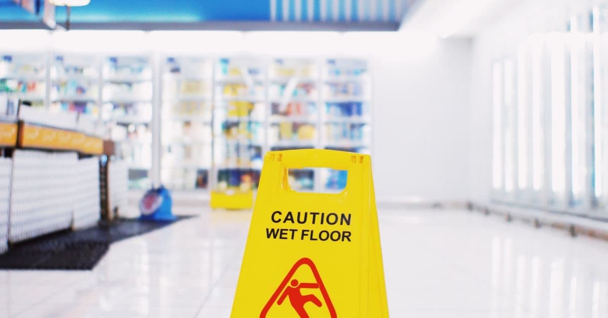 Yellow wet-floor warning sign in a store aisle