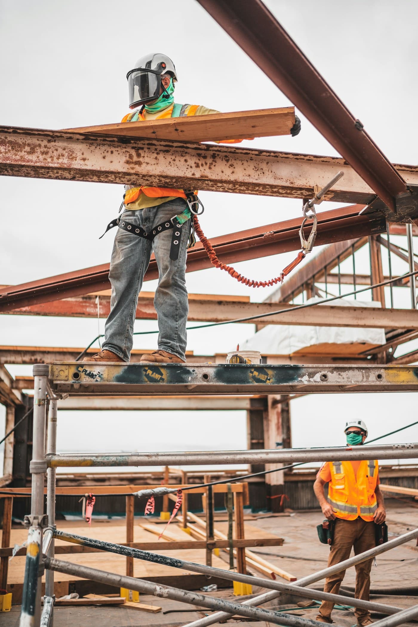 Construction workers wearing hard hats and safety harnesses